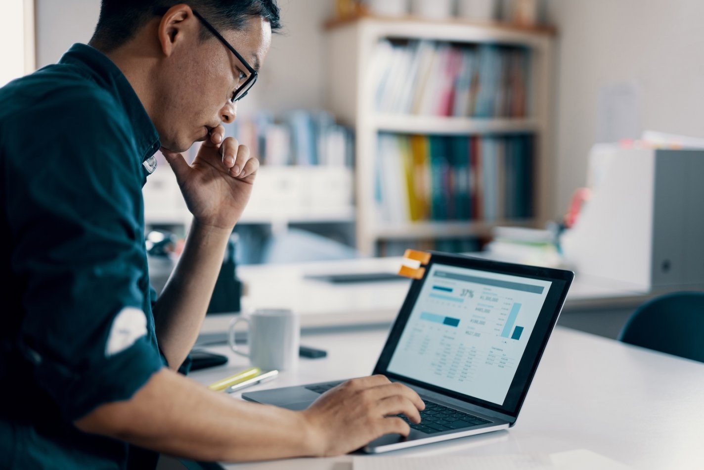 Business owner using accounting and job costing software on a laptop