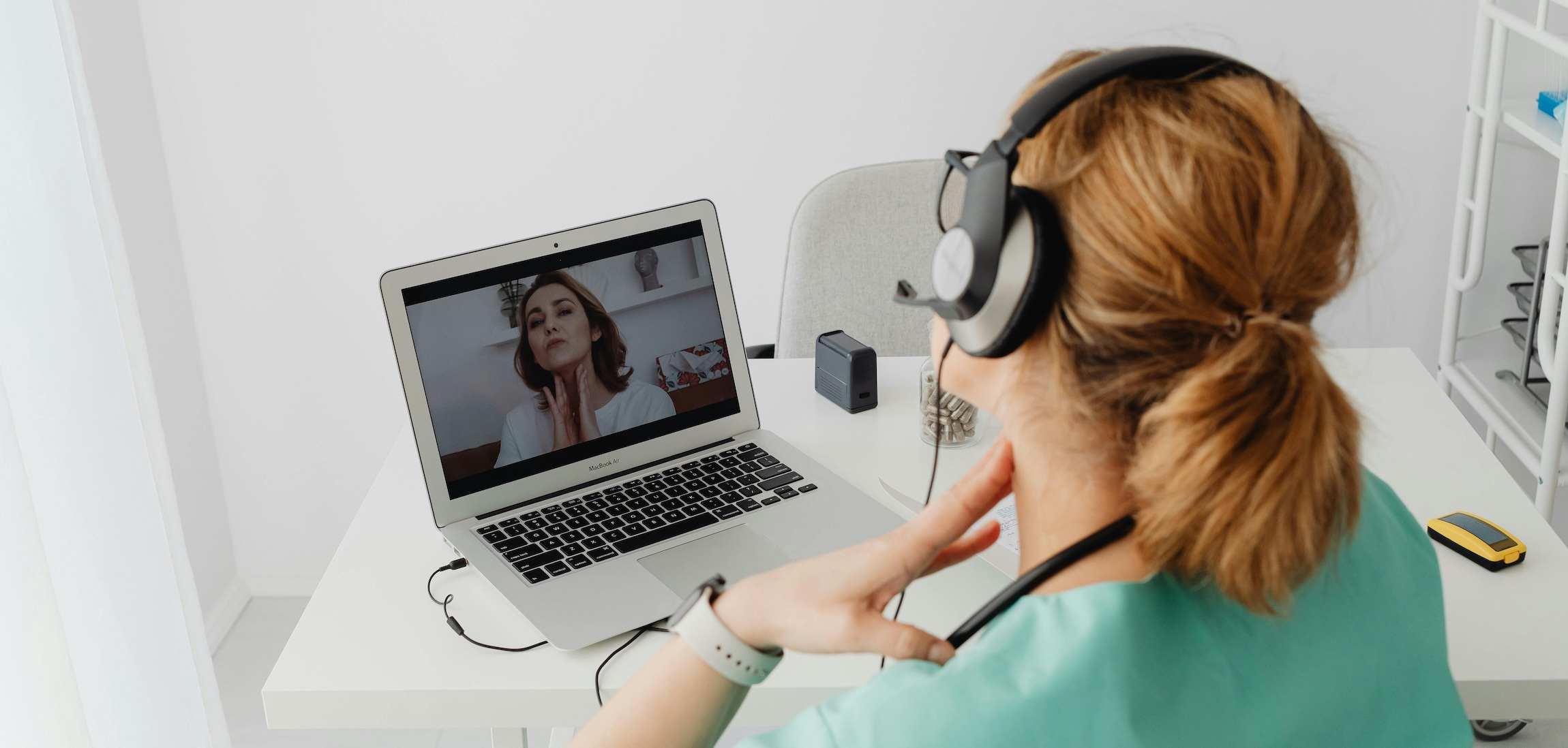 Nurse conducts telehealth visit with woman on laptop screen.