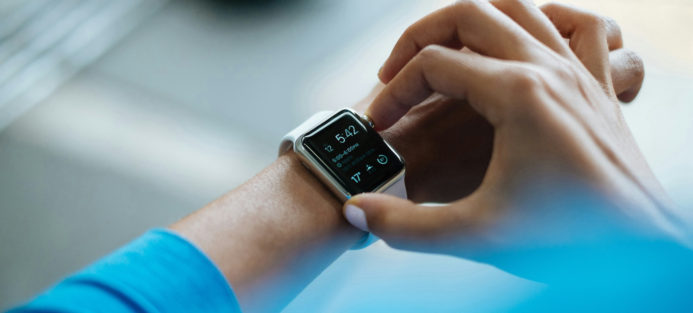 Woman adjusts an Apple Watch on her wrist.