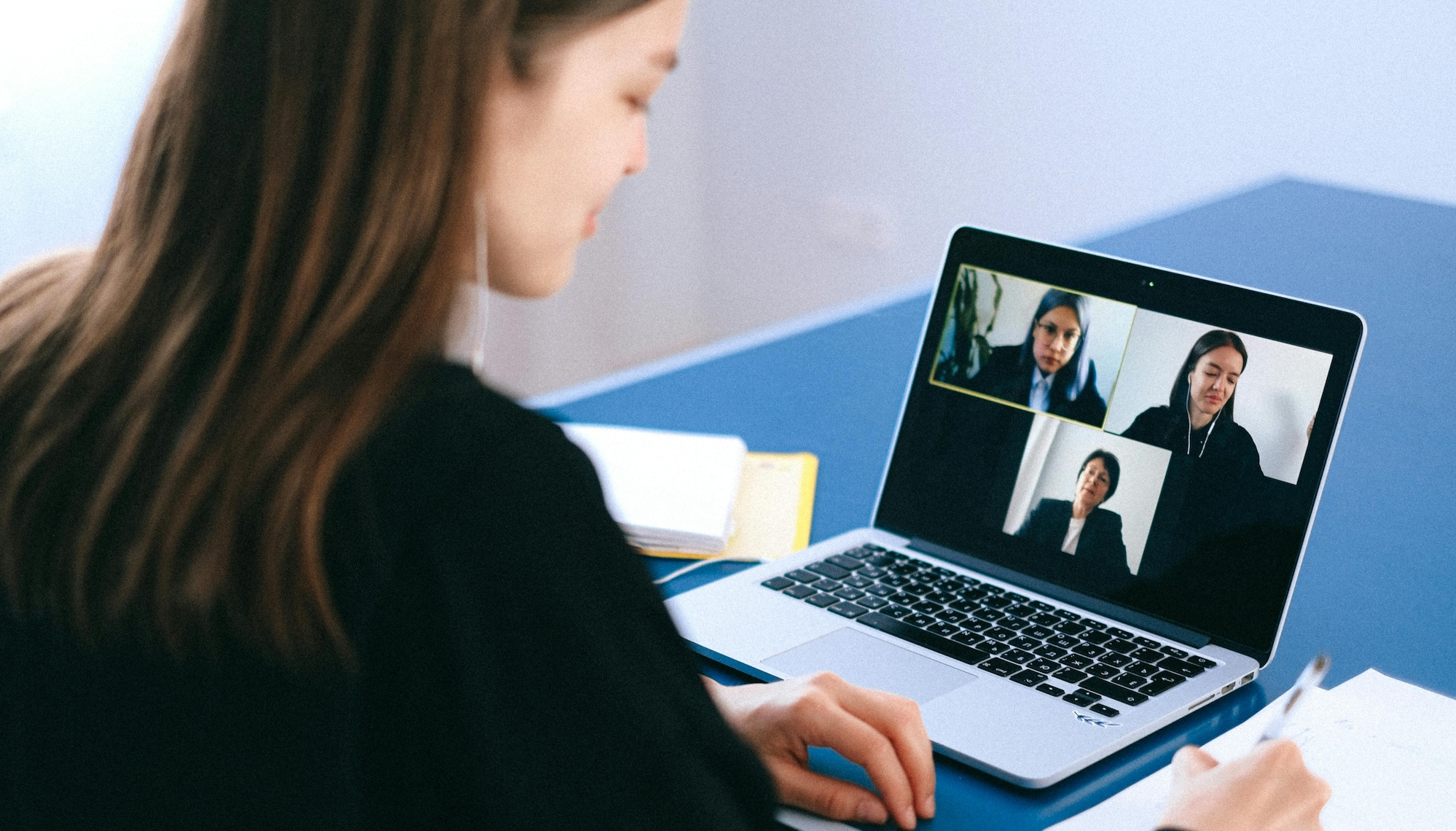 Remote worker speaks with international remote employees over a video conference call.