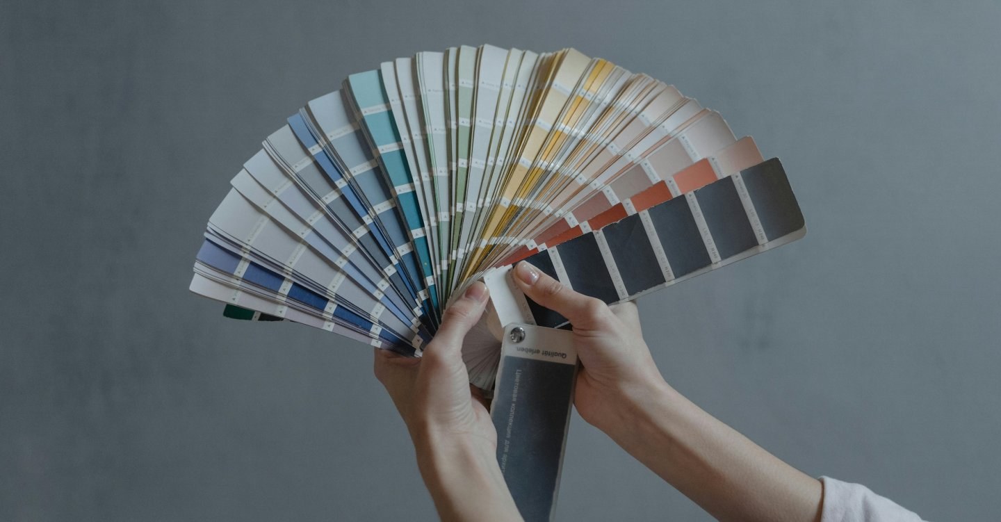 A person fans out a large ream of paint samples as they choose a color.