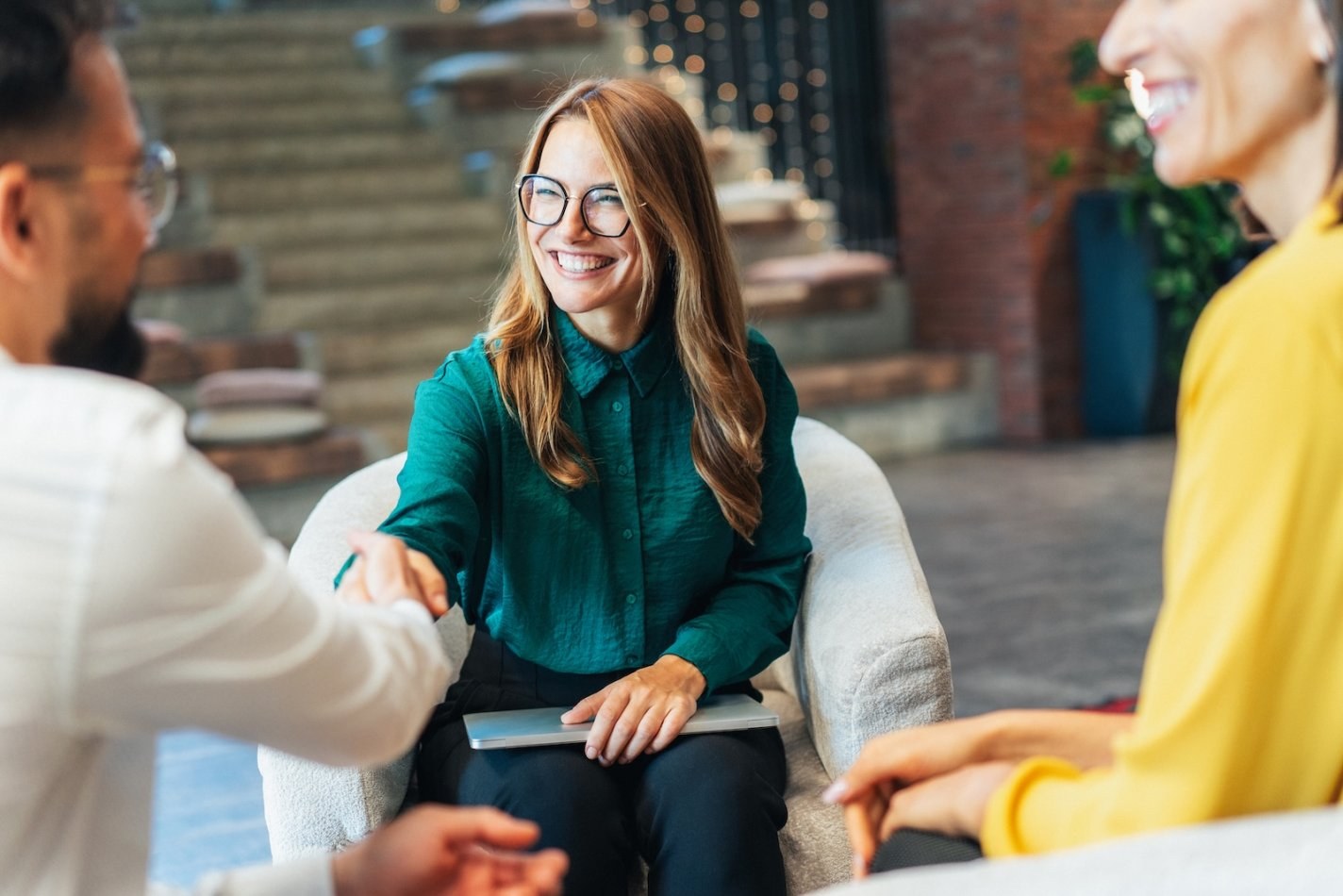 Female interviewee shakes hands with one of two interviewers