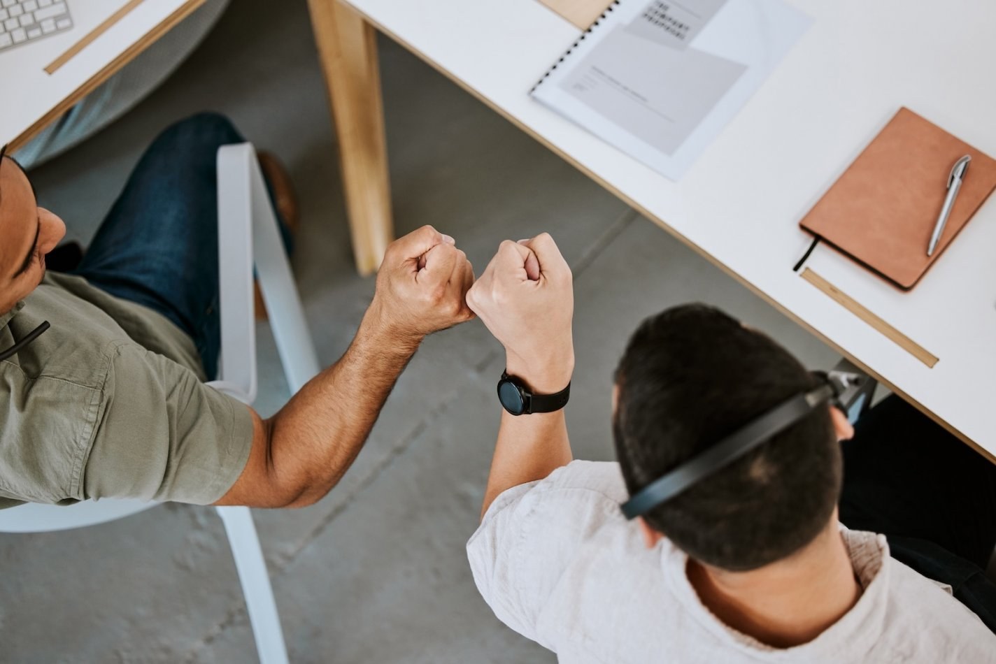 Two call center employees fist bump each other in celebration