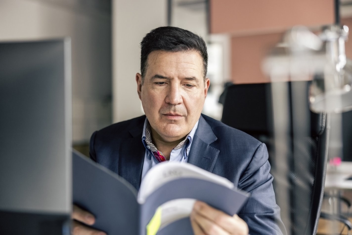 Employee reviews employee handbook at his desk