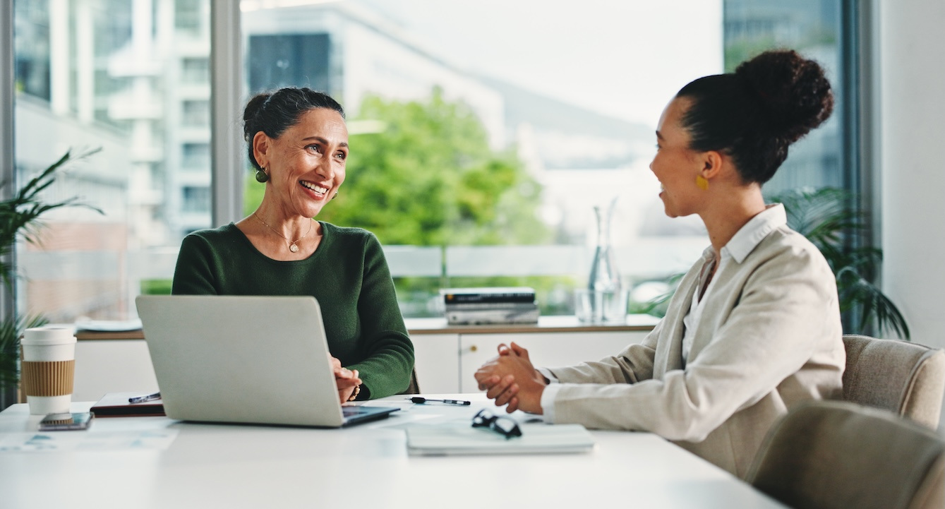 Laptop, discussion and business women in office with feedback on corporate performance review. Meeting, computer and female hr manager with employee for advice on career evaluation in workplace.