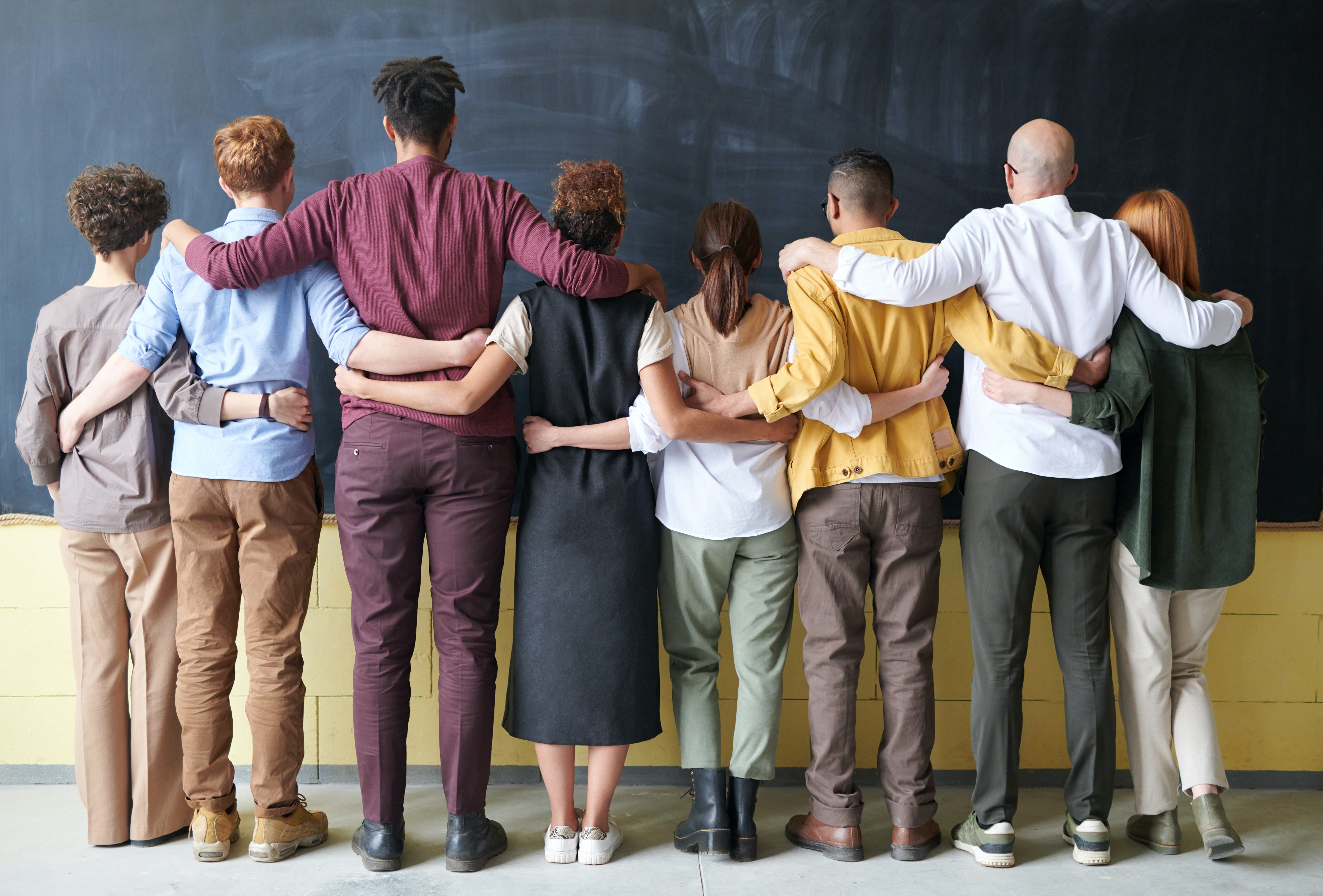 Group of people standing together with arms on one another