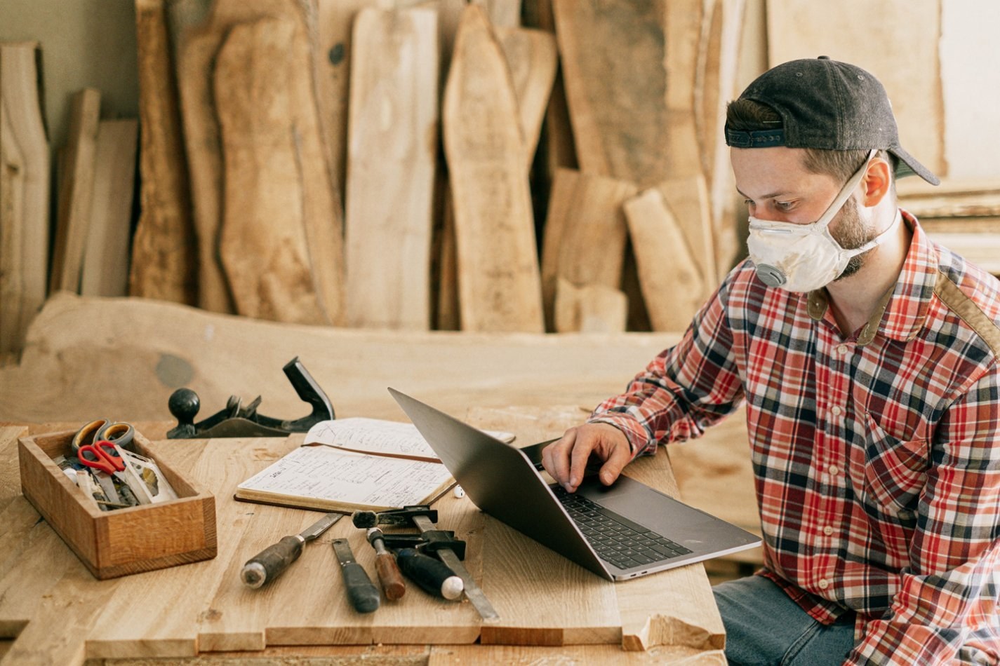 Person working on laptop in wood shop