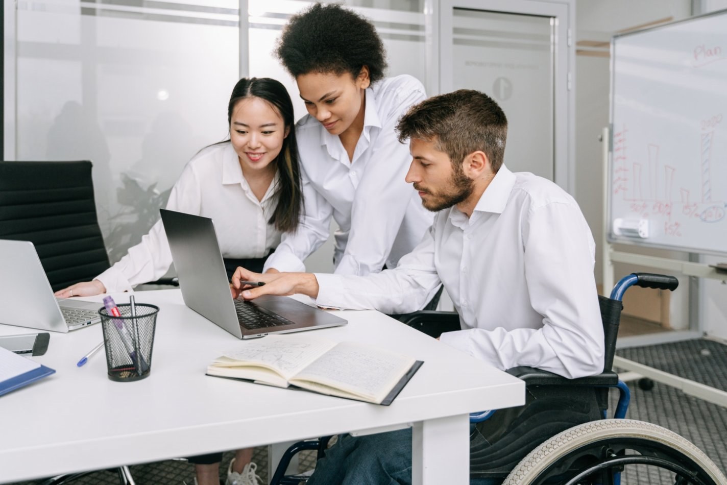 three people looking at computer working together