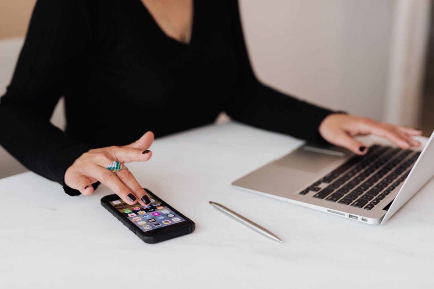 woman on computer and playing on phone