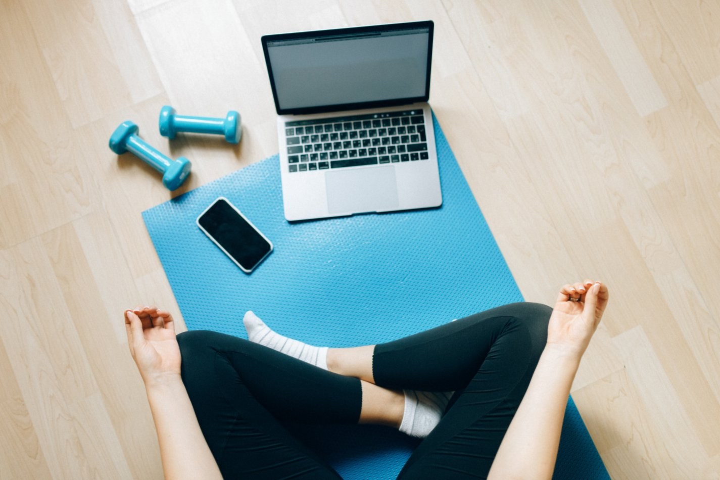 Woman doing yoga at home with computer and phone