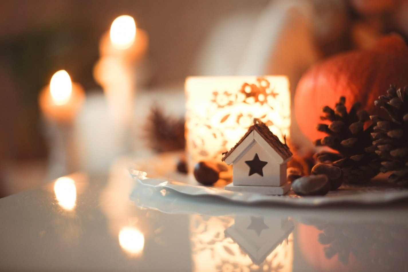 Bright, decorative holiday decor home in front of blurred background of twinkling holiday lights.
